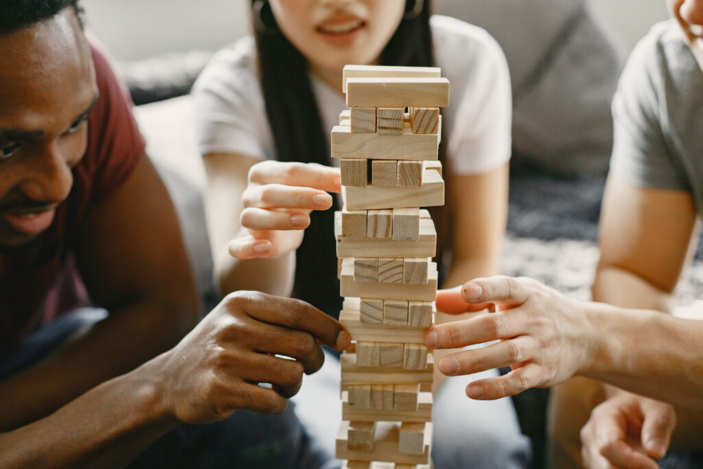 three friends playing jenga in the living room